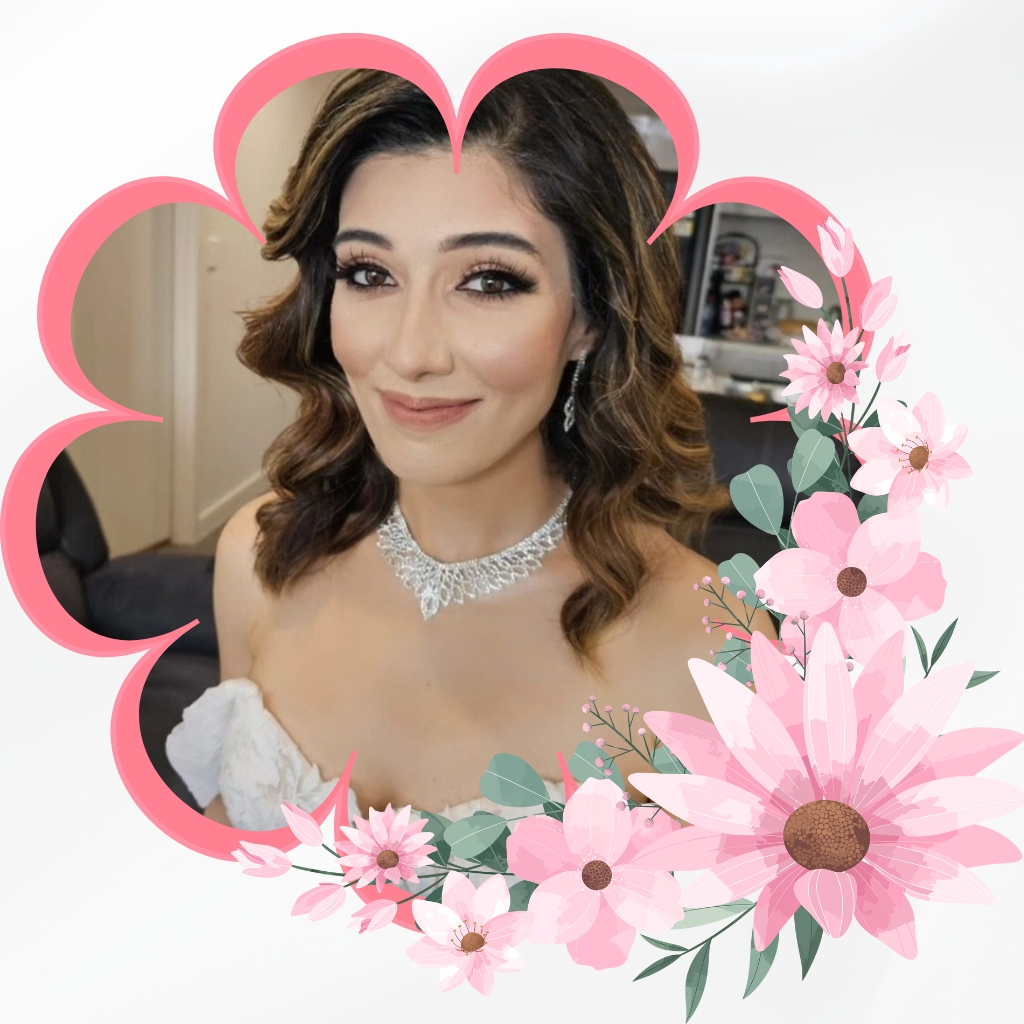 A woman in a bridal dress showcases her elegance with a delicate necklace, surrounded by pink and white flowers, completing her Bridal Makeup in Guildford.